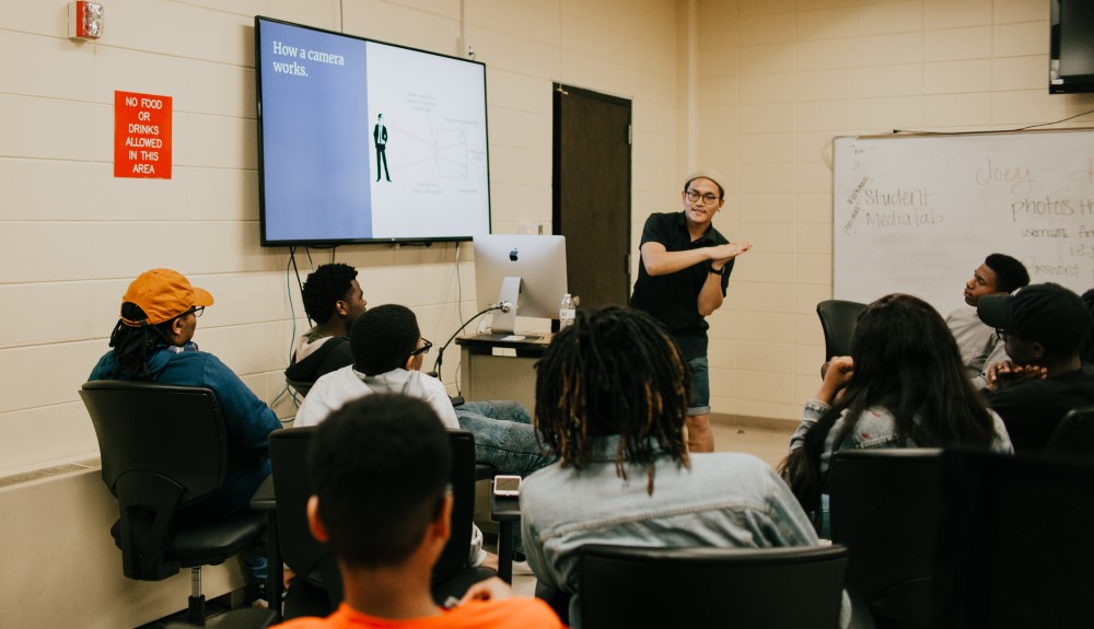 Joey Park presents a PowerPoint entitled “How a Camera Works” to a group of LSU students.