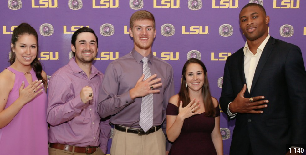 students pose with rings at LSU ring ceremony